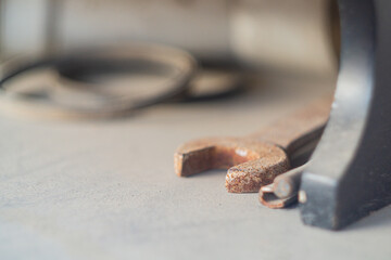 Locksmith tools such as a wrench and an adjustable wrench with selective focus lie on a beige surface and gather dust idle.