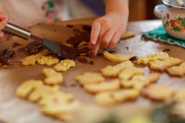 Child decorating cookies with chocolate