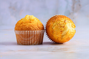 Two Homemade Muffins on Light Marble Background