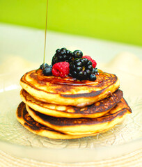 Platillo de hot cakes con miel  y frutos rojos