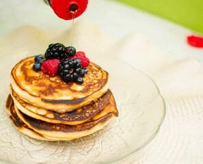 Delicioso hot cakes con frutos rojos y miel cayendo  