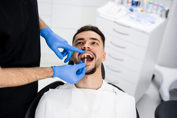 Fototapeta premium Analysis of patients tooth shade by dentist. Patient chooses tooth shade before bleaching.