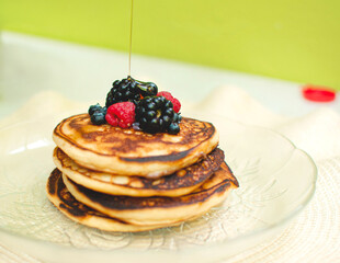Imagen horizontal de unos hot cakes caseros con frutos rojos 