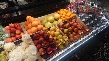 A colorful assortment of fruits including apples, pears, and citrus fruits on display at a market. Ideal for food, health, and nutrition themes.