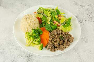 Savory ground beef with steamed broccoli, carrots, brown rice, and a vibrant mixed green salad.