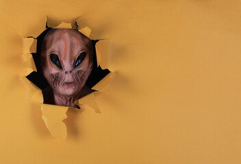 alien in a yellow paper hole