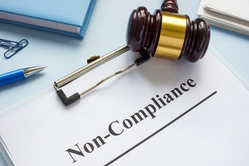 Clipboard with document about non-compliance and gavel.