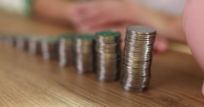 Ceramic piggy bank stands near stacks of coins put in row on wooden table. Small money container for finance saving and accumulation