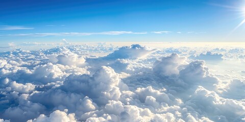 Fototapeta premium A vast expanse of fluffy white clouds stretches out beneath a clear blue sky