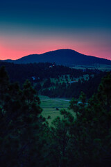 Helena Suburb Sunrise Skyline over the Helena National Forest and Avalanche Butte in Montana, USA: Tranquil mountain valley summer landscape with pink sky