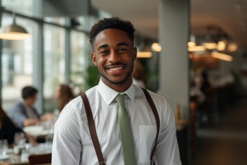 Obraz premium Portrait of a smiling young male waiter in restaurant