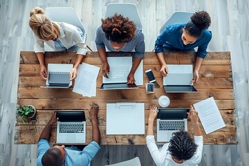 diverse group of professional businesspeople working together on multiple devices in a modern office setting, captured from a high overhead angle.