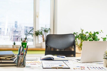 laptop, notepads flower pen and other at office desk