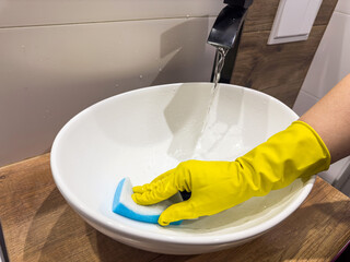 woman washing or wipes the sink in the bathroom