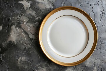 A stylish white plate with gold edges set against a textured gray backdrop