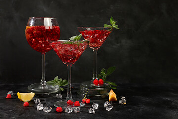 Lemonade cocktail with tequila, gin, rum, vodka, liqueur, lime, ice and fresh raspberries, bar and party concept, restaurant and cafe advertising card, black background, selective focus.