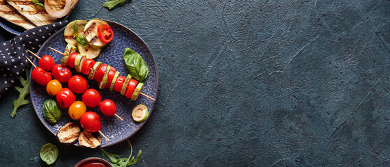 Plate with tasty grilled vegetables on blue background