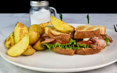 bacon , lettuce ,and tomato sandwich with potato wedges