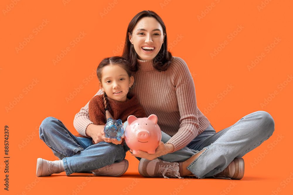 Poster little girl and her mother with piggy banks sitting on orange background