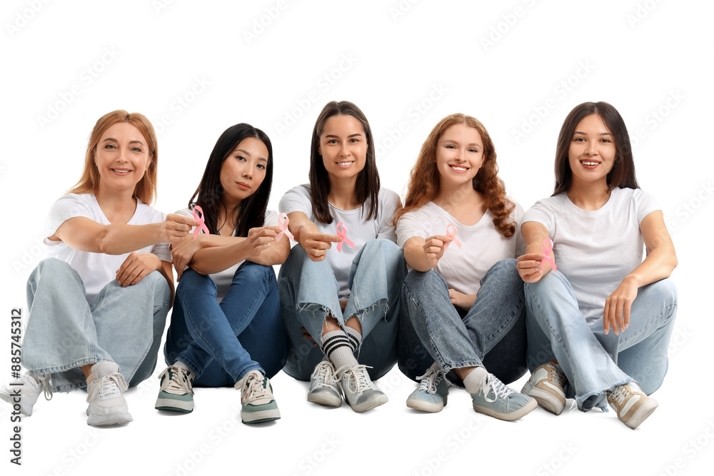 Wall mural Beautiful women with awareness pink ribbons sitting on white background. Breast cancer concept