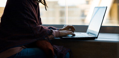 Girl is working on a laptop at home online.