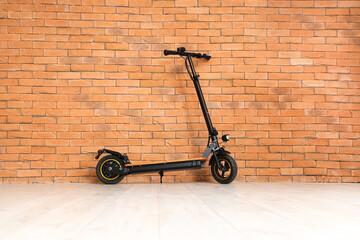 Modern electric kick scooter on brick wall