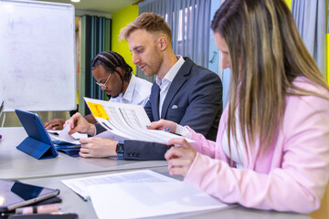 Obraz premium Three people are sitting at a table with papers in front of them