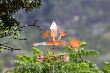 A metal weathervane, crafted from iron, has a rich rusty patina, enhancing its vintage appeal. The...