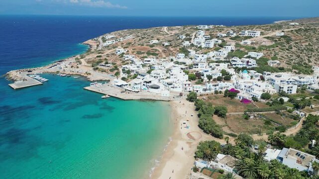 View Donousa Island from above to see its stunning beauty: clear turquoise waters, sandy beach, white village on hill. Experience Cyclades, Greece