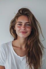 Fototapeta premium A woman posing in a casual outfit, featuring long brown hair and a white t-shirt