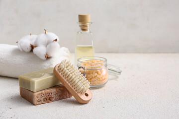 Soap bars, sea salt in glass jar, massage body brush and towel on white background