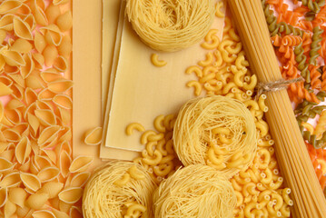 Different tasty uncooked pasta on table, closeup