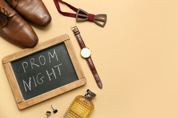 Chalkboard with text PROM NIGHT, male shoes and wristwatch on beige background
