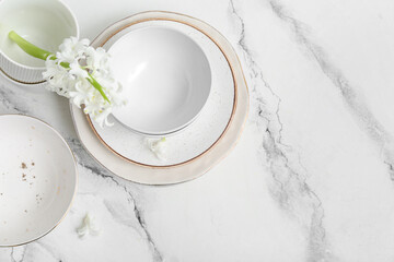 Beautiful tableware with flowers on marble background