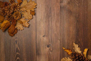 Cones and leaves on wooden background. Autumn composition. Copy space, top view