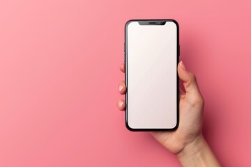 Woman's hand holding a blank screen mobile phone isolated on a pink background with copy  space
