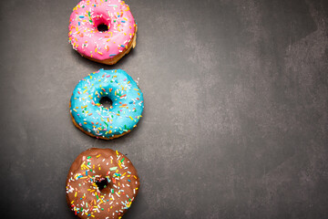 Delicious dessert. Pink, blue and chocolate donuts with multicolored sprinkles.