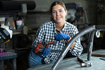 Portrait of young female worker at metallurgical plant with a caliper in her hands