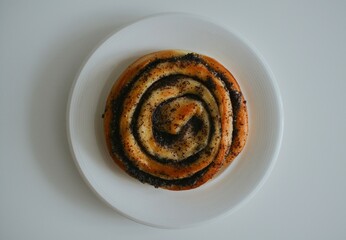 delicious bun with poppy seeds just out of the oven on a white plate in a cafe on a white background