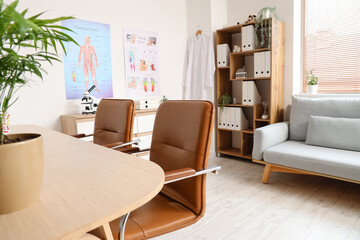Interior of medical office with doctor's workplace, sofa and shelf unit