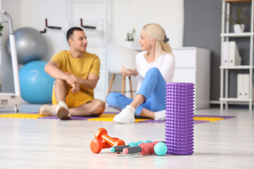 Massage rollers with ball and dumbbells in rehabilitation center, closeup