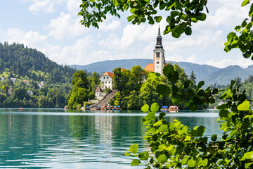 Panoramic view from Lake Bled, beauty heritage in Slovenia. Island with church and castle in the background create a dream setting. View from Ojstrica and Mala Osojnica with the heart-shaped bench.