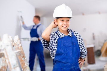 Portrait of smiling preteen boy engaged in home improvement and renovation with his father