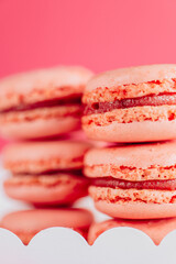  Macaron cakes.white cardboard box filled with pink macarons set against a pink backdrop.French pastries set. macarons close-up background.Assorted sweet pastries. 
