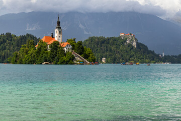 Panoramic view from Lake Bled, beauty heritage in Slovenia. Island with church and castle in the background create a dream setting. View from Ojstrica and Mala Osojnica with the heart-shaped bench.