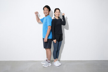 Fototapeta premium スポーツや健康などをする50代の夫婦の全身のカメラ目線 ガッツポーズ