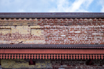 Vintage Building from the 1800's with Red and Yellow Brickwork and a Tin Awning.