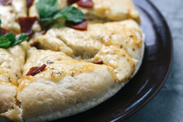 Close Up Of Margerita Cheese Pizza On Black Plate Topped With Sausage 