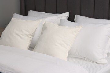 Many soft pillows on bed at home, closeup