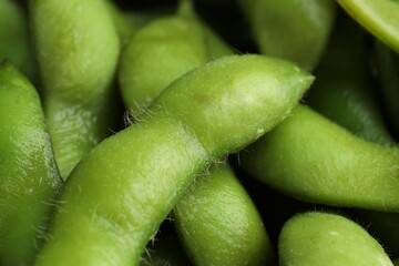 Fresh edamame pods as background, closeup view